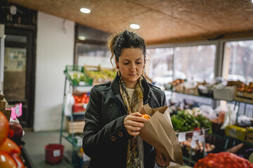 Woman grocery shopping at the local store with paper bag