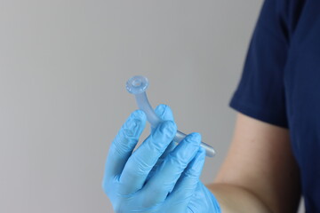 Professional wearing gloves holding a nasopharyngeal tube in the hands. Copy space in te left side