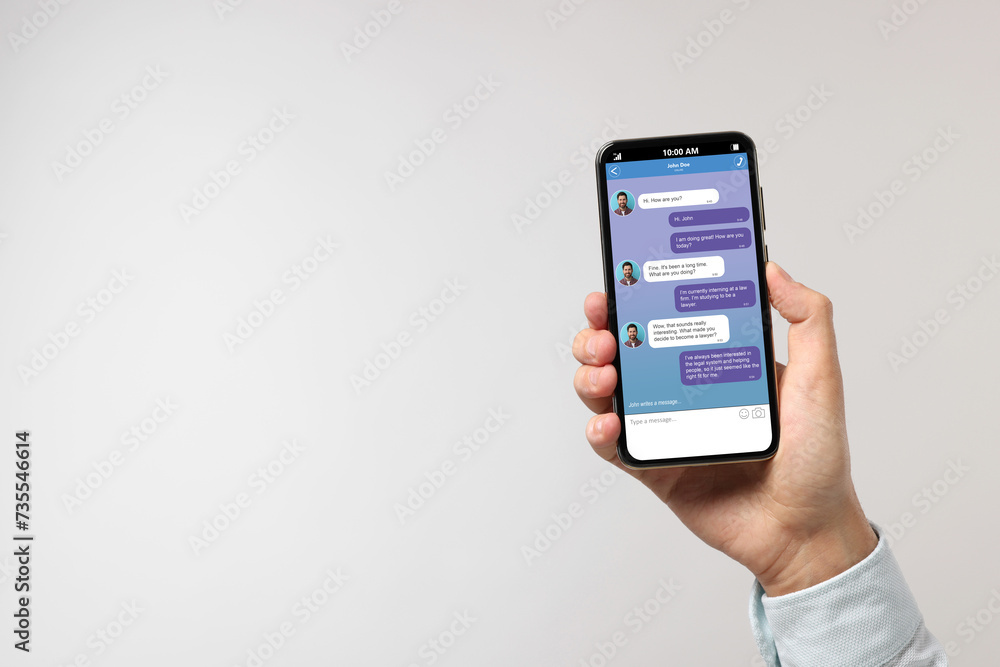 Poster man texting with friend using messaging application on smartphone against light grey background, clo