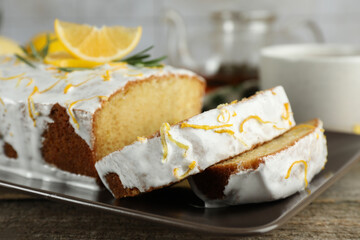 Tasty lemon cake with glaze on wooden table, closeup