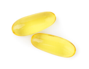 Yellow vitamin capsules isolated on white, top view