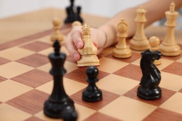 Little child playing chess, closeup of hand