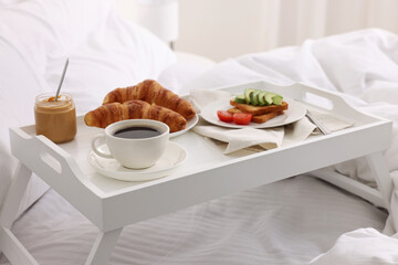 Good morning. Tray with tasty breakfast on bed at home