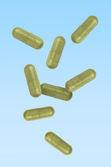 Vitamin. Capsules falling on light blue gradient background