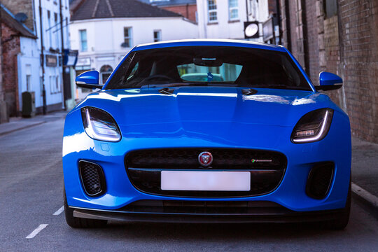 Leamington, UK - August 9 2020 : A Jaguar F-Type sports coupe in bright blue with modern urban backdrop and large wheels. No numberplate or people professionally retouched. Tata Motors Land Rover