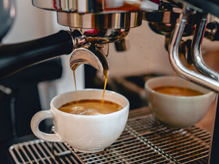 Coffee extraction from the coffee machine with a portafilter pouring coffee into a cup,Espresso poruing from coffee machine at coffee shop