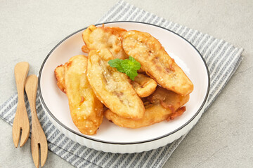 Pisang Goreng Wijen or banana fritters with sesame seed served in white plate. Indonesian food
