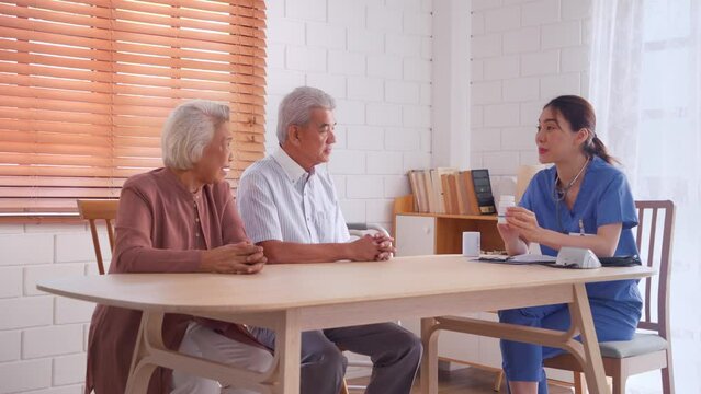 Asian caregiver nurse examine senior couple patient at home together. 