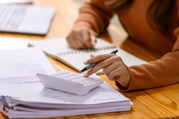 A young woman working with papers and documents at a desk in the office.