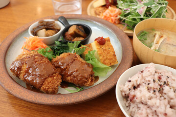 レストランで食べるコロッケ、フライ、ライス、スープ、サラダ、煮物のランチ