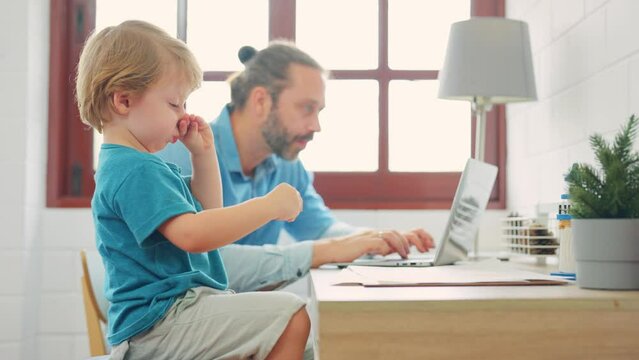Caucasian attractive father use laptop computer with young son beside. 