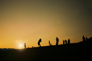Fototapeta na wymiar Silhouette people standing on the hill under sunshine light