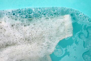 Women's lace dress soaked in water dissolved detergent with white foam bubble. Laundry concept