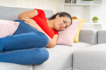 Woman Experiencing Abdominal Pain Lying on Couch