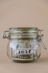Glass jar full of American currency dollars cash banknote with text 2025 year. Preparation saving...