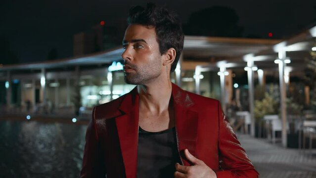 Brutal man relaxing night poolside club in red suit close up. Rich latin macho