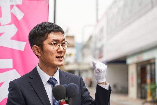 街中で選挙活動をするスーツを着た男性
