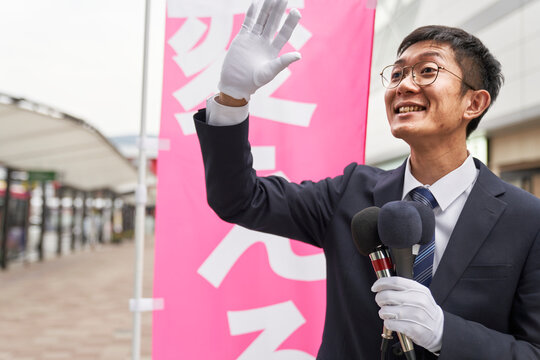 街中で選挙活動をするスーツを着た男性