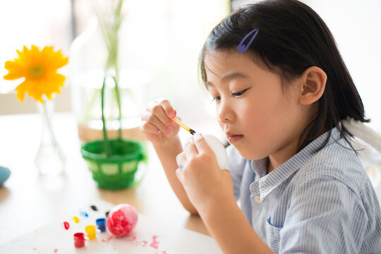 イースターエッグに色を塗っている女の子