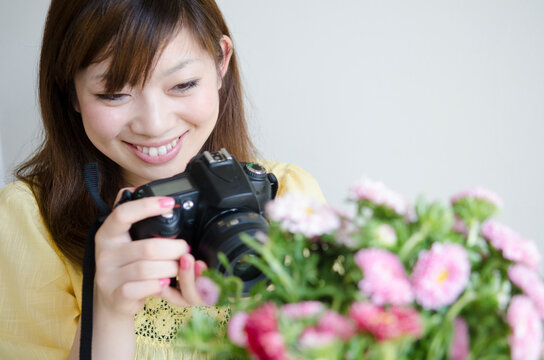 一眼レフでお花の写真を撮っている女性