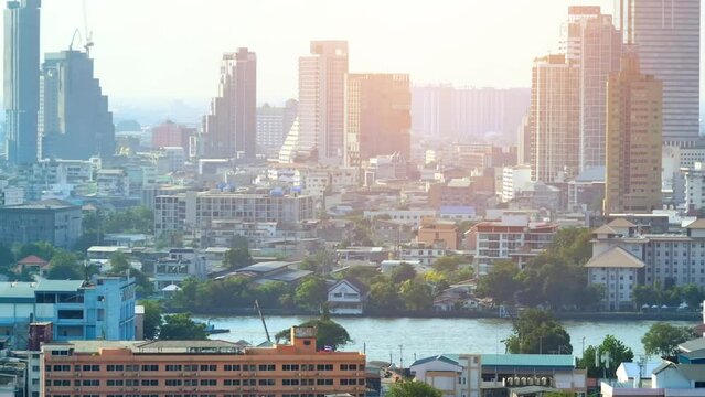 4K - Bangkok Thailand: Aerial view, Urban skyline bathed in sunset hues, drone soars above downtown's business hub, skyscrapers flank the river. Adventure concept.

