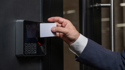A man opens the door with a card. Modern electronic lock. Keyless Entry - obrazy, fototapety, plakaty