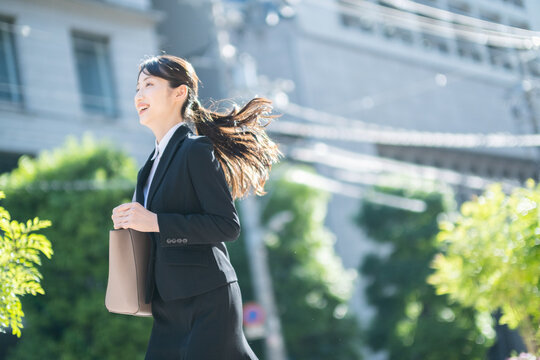 スーツを着て走る女性