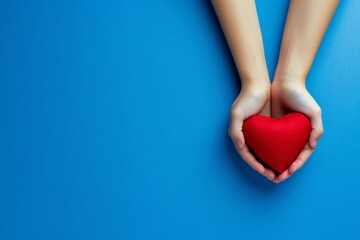 Hands holding a red heart Symbol of love and compassion Blue background Emotional and touching