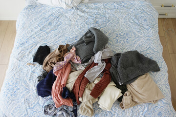 messy bed with cloths in early morning , messy bed after waking up 