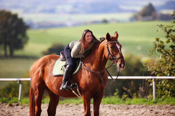 Obraz premium Horse woman rider riding in the sunshine at the riding arena.