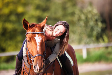 Horse woman rider riding in the sunshine at the riding arena.