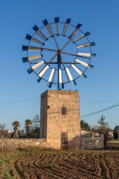 close-up view of a modern windmill with steel blades in the interior of Mallorca under a blue sky