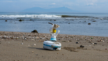 Broken electrical fan on beach with view of ocean, plastic and electrical junk pollution, on the tropical island destination of East Timor, Southeast Asia 
