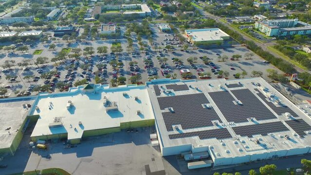 Aerial view of many photovoltaic panels installed on IKEA shopping mall roof top for producing of green ecological electricity. Production of sustainable energy concept.