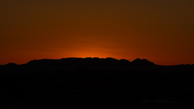 Arizona sunrise with mountains in silhouette and sun rising