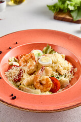 Gourmet Caesar Salad with Succulent Shrimp and Quail Eggs on a Terracotta Plate