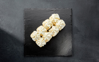 Roll in a wheat tortilla topped with cream cheese; a unique fusion of sushi and western flavors