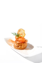 Elegant salmon profiterole garnished with dill on a minimalist white plate, ideal for gourmet finger food concept