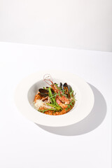 Tomato risotto with seafood on a white plate, perfect for Mediterranean cuisine and healthy eating concepts