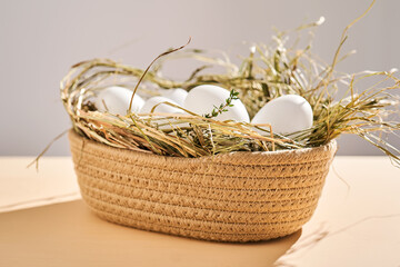 Fototapeta na wymiar Wicker basket with farm natural white eggs.