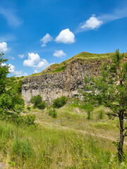 Fototapeta na wymiar The basalt columns of Racos, Coloanele de bazalt de la Racos, stone wall in nature with blue sky, Racos, Brasov, Transylvania, Romania
