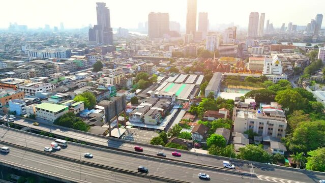 4K - Bangkok Thailand: Drone Aerial view, Swiftly maneuvering through the urban expanse, the drone reveals a skyline dominated by high-rise structures, a symbol of progress and urbanization. 
