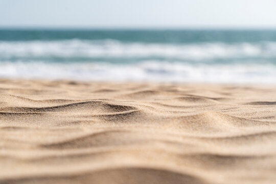 Beautiful sandy beach seascape background sand texture. Blur bokeh sea, ocean, sky and sand focused