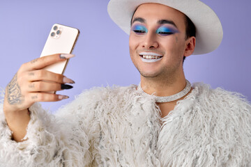 Stylish transgender man LGBTQ taking photo on phone posing with gorgeous manner and self-confidence...