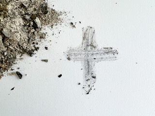 Ash Wednesday flat lay of ashes next to the ash cross. Ash Wednesday is the Christian symbol during...