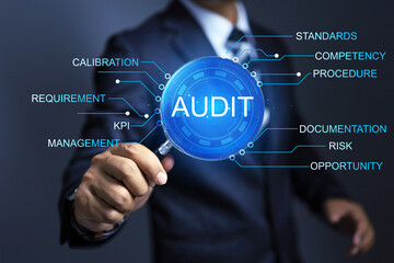 Auditor holds magnifying glass to conduct the annual audit where every company and organization...
