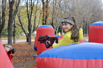 A girl  playing laser tag in an autumn park