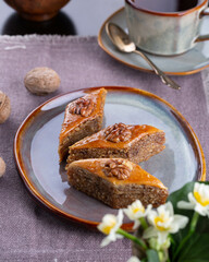 Novruz pastry - shekerbura, pakhlava, sweet kete, bishi, badambura on white tablecloth in Novruz setting with festive wheat grass and pear shape eastern glasses with tea, New year celebration in Baku