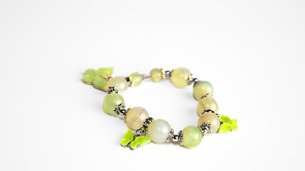 Beads from light green and yellow stones on a white background