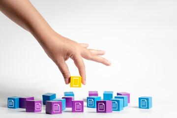 hands pick up colored wooden blocks displaying tablet symbols, promoting paper reduction and digital document management